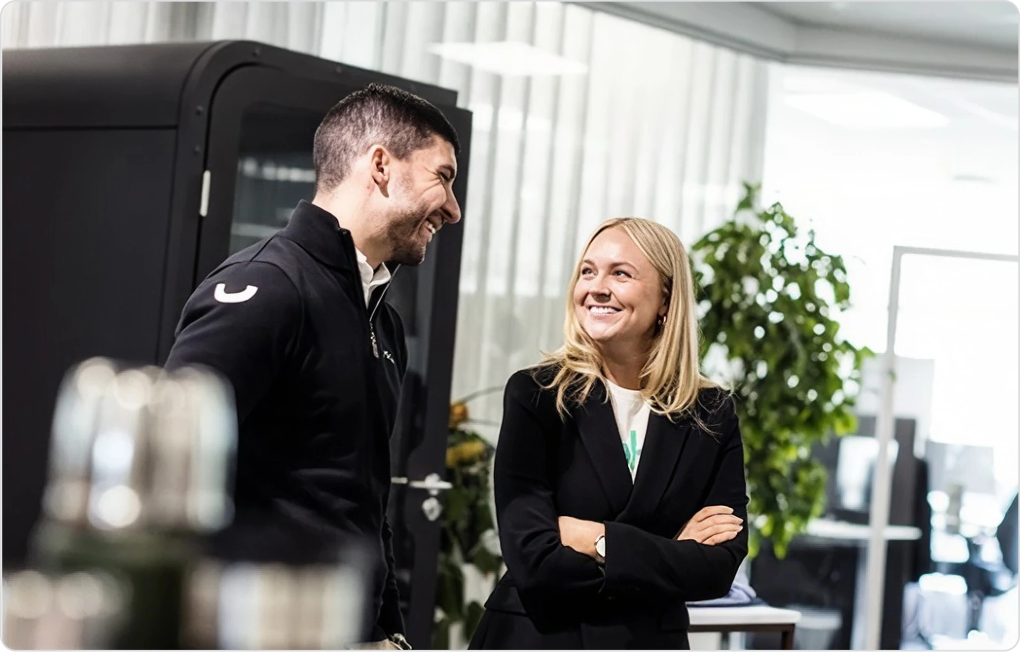 Tv&aring; kollegor i Vokys kontor med profilkl&auml;der p&aring; bordet bredvid dem.